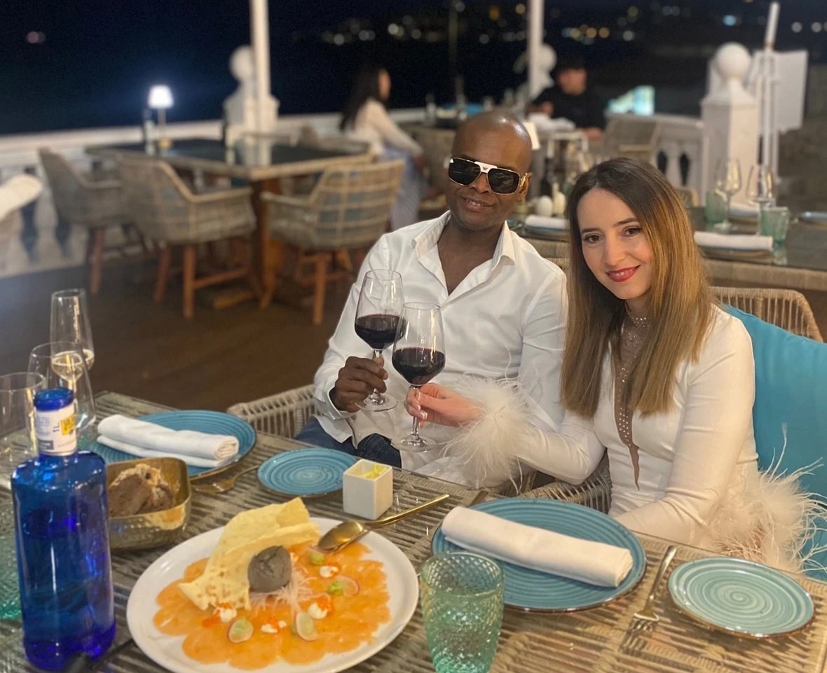 Una pareja brindando con vino en una cena junto al mar